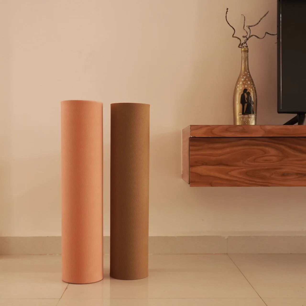 Two rolled mats in peach and mocha